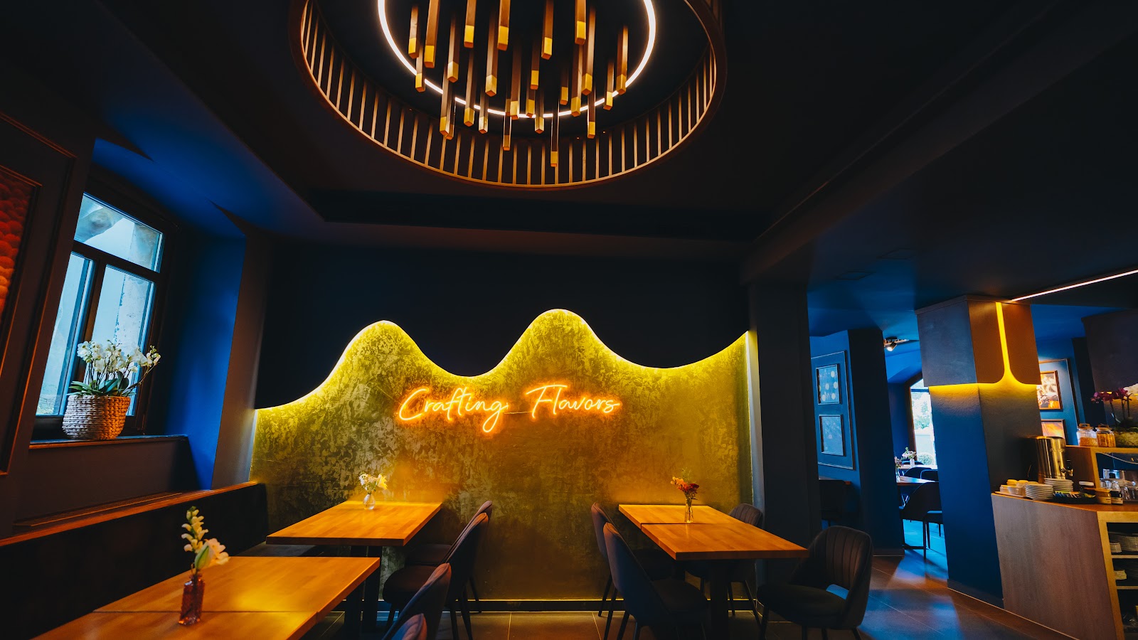 Gastraum des Saigon Blue mit Leuchtschrift „Crafting Flavors“